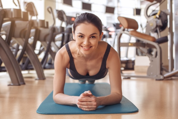 Jonge vrouwelijke training in sportschool gezonde levensstijl oefening op yogamat