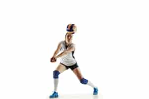 Gratis foto jonge vrouwelijke volleyballspeler die op witte muur wordt geïsoleerd. vrouw in sportuitrusting en schoenen of sneakers trainen en oefenen. concept van sport, gezonde levensstijl, beweging en beweging.