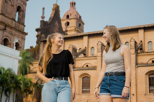 Jonge vrouwelijke vrienden staan op de muur van de kathedraal van Santa Cruz de la Sierra