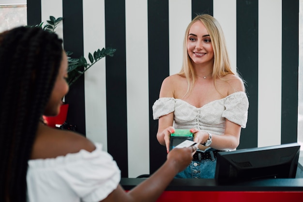 Gratis foto jonge vrouwen betalen voor boodschappen