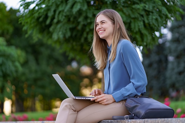 Jonge vrouwen die aan laptop op het stadsplein werken