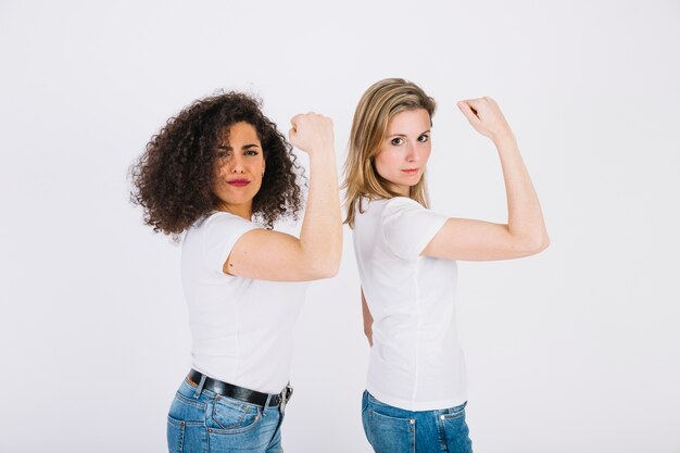 Jonge vrouwen die bicepsen tonen