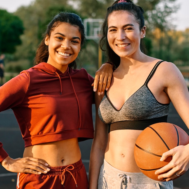 Jonge vrouwen die met een basketbal stellen