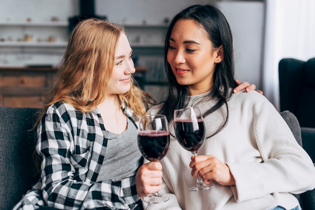 Jonge vrouwen die met wijnglazen roosteren