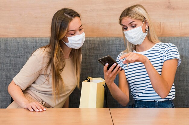 Jonge vrouwen die mobiele telefoon samen controleren