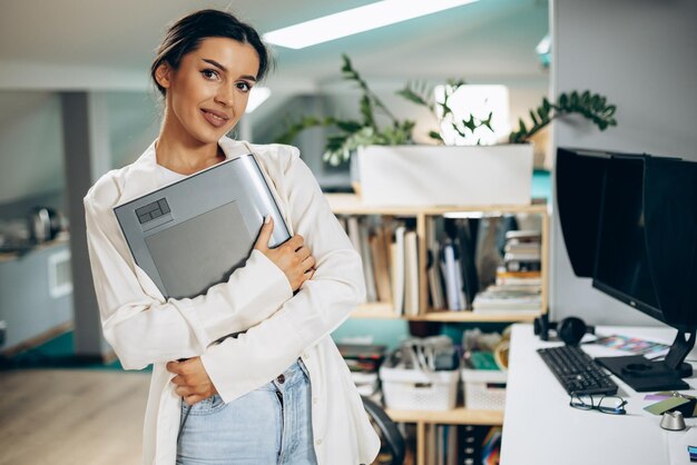 Jonge vrouwen digitale ontwerper die aan tablet en computer werkt