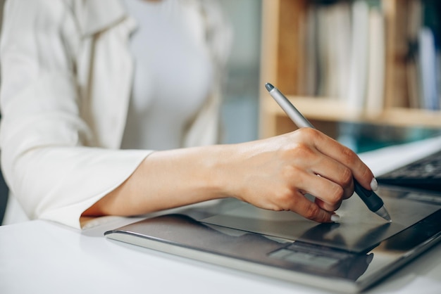 Jonge vrouwen digitale ontwerper die aan tablet en computer werkt