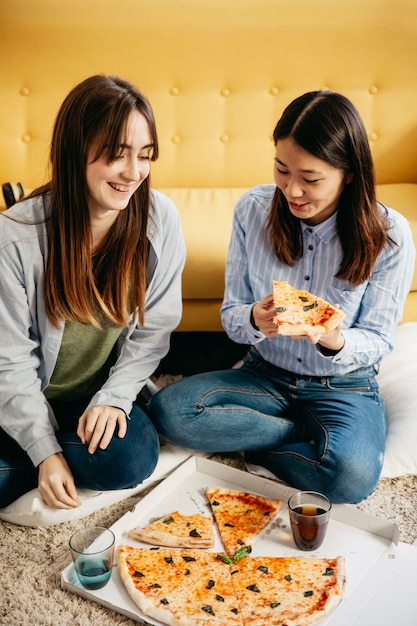 Gratis foto jonge vrouwen met pizza-feest