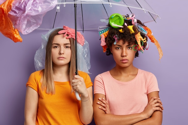 Gratis foto jonge vrouwen poseren met plastic afval