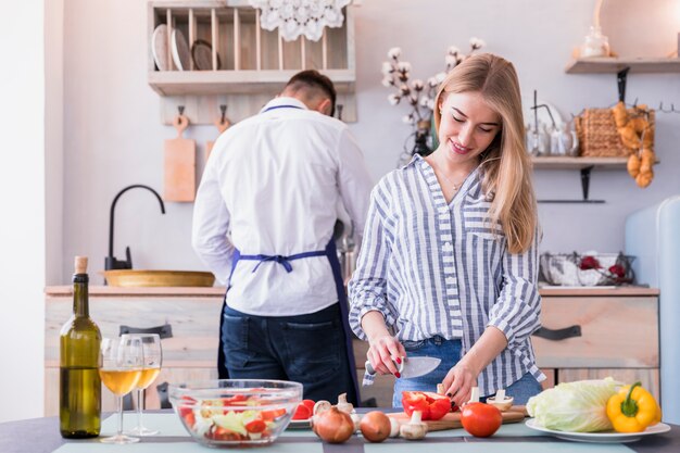 Jonge vrouwen scherpe groenten in keuken