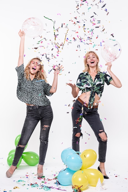 Gratis foto jonge vrouwen vieren met confetti