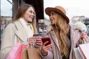 Gratis foto jonge vrouwen winkelen in de stad