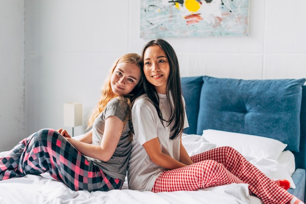 Gratis foto jonge vrouwen zittend op bed