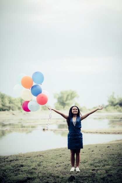 Jonge vrouwenhand die kleurrijke ballons houdt