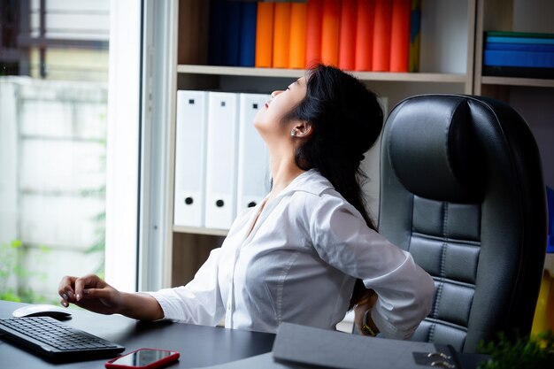 Jonge werkende vrouwen rugpijn terwijl het werk