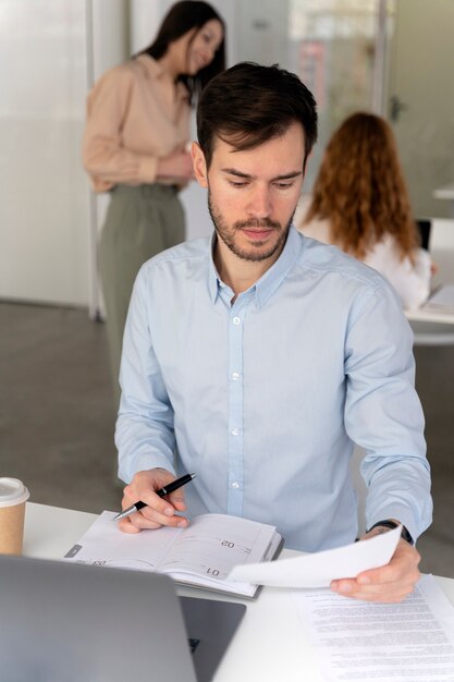 Jonge zakenman aan het werk aan haar bureau met laptop