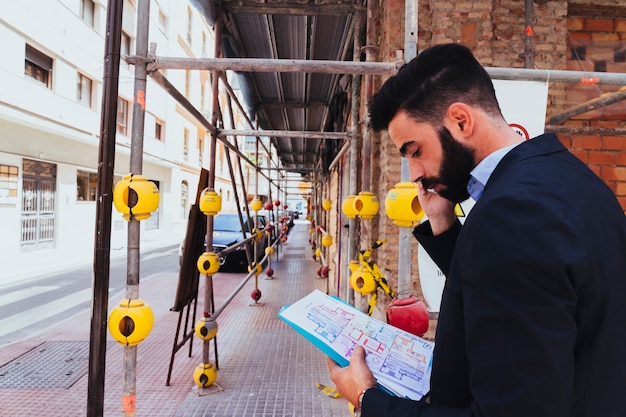 Jonge zakenman aan het werk en aan het praten over de telefoon