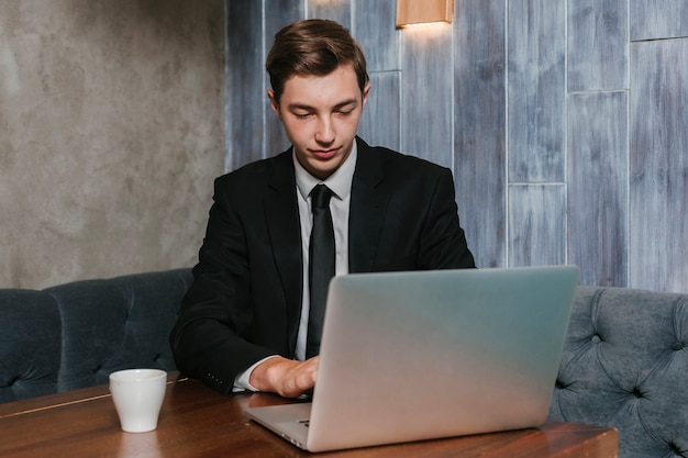 Jonge zakenman die aan laptop werkt