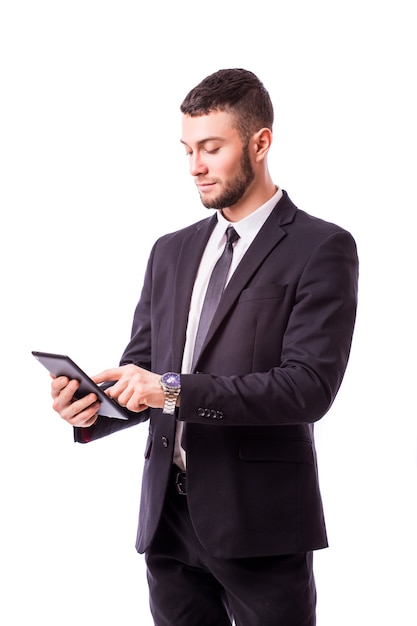 Jonge zakenman die een digitale tablet houdt, die op witte muur wordt geïsoleerd