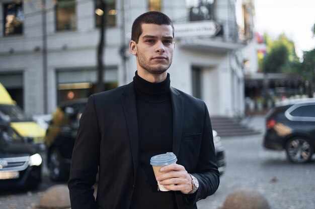 Jonge zakenman die naar het werk met koffie gaat