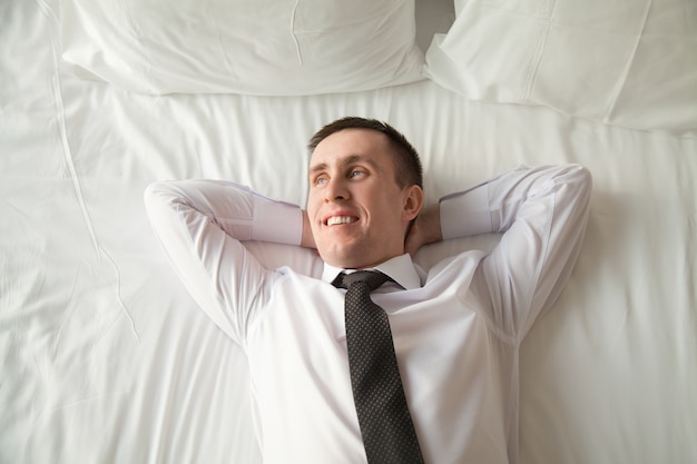 Jonge zakenman ontspannen in bed
