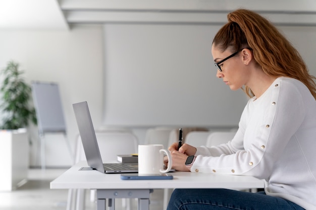 Gratis foto jonge zakenvrouw aan het werk op kantoor