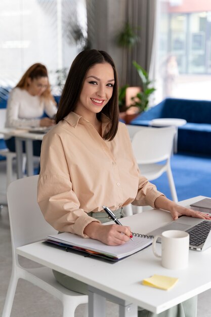 Jonge zakenvrouw die aan haar bureau werkt met laptop