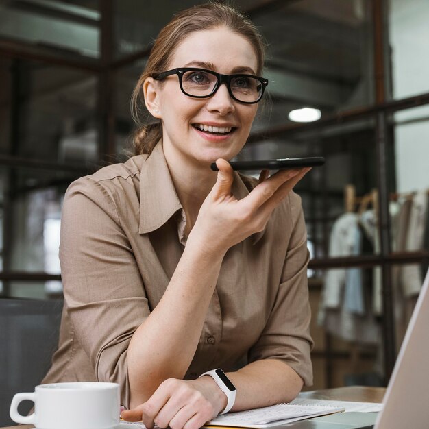 Jonge zakenvrouw praten aan de telefoon tijdens een vergadering