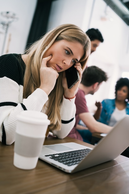 Jonge zakenvrouw praten aan de telefoon