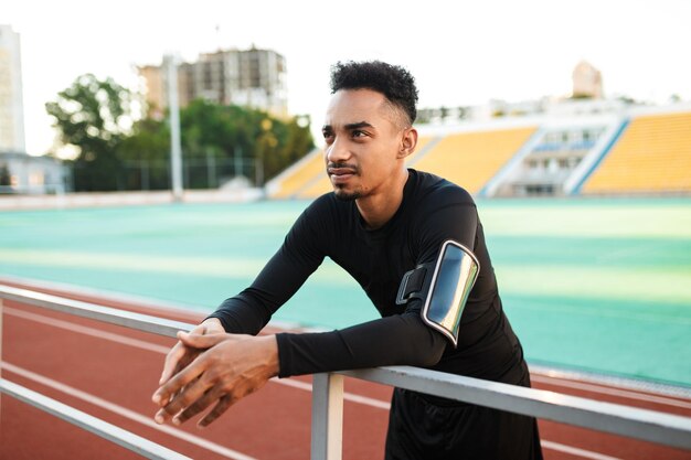 Jonge zelfverzekerde Afro-Amerikaanse sportman op training in het stadsstadion