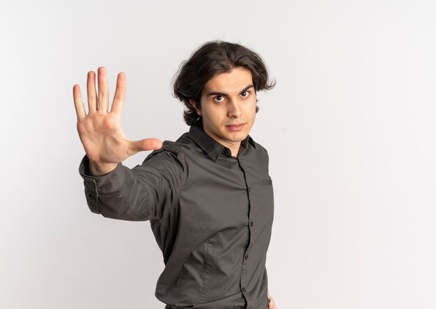 Jonge zelfverzekerde knappe blanke man gebaren stoppen handteken geïsoleerd op een witte achtergrond met kopie ruimte