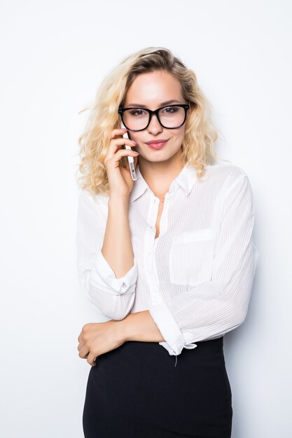 Jonge zelfverzekerde onderneemster die op de mobiele die celtelefoon spreekt op wit wordt geïsoleerd