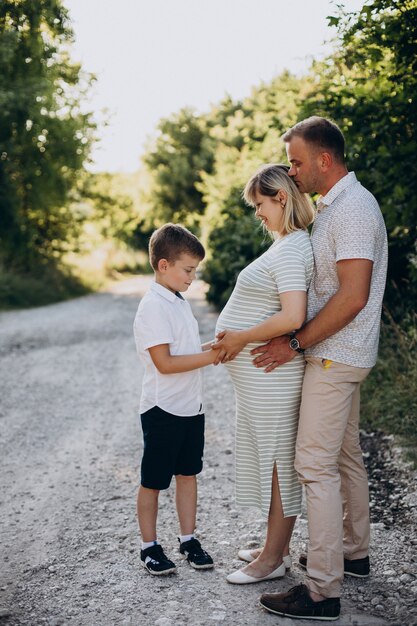 Jonge zwangere vrouw met man en zoon in een bos