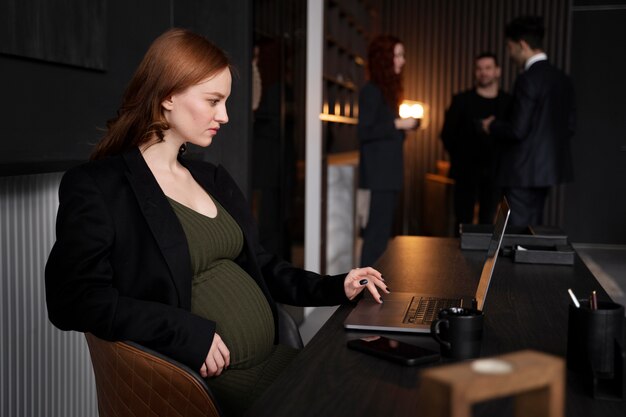 Jonge zwangere vrouw op het werk