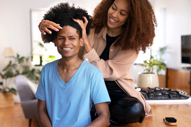 Gratis foto jonge zwarte mensen die voor afrohaar zorgen