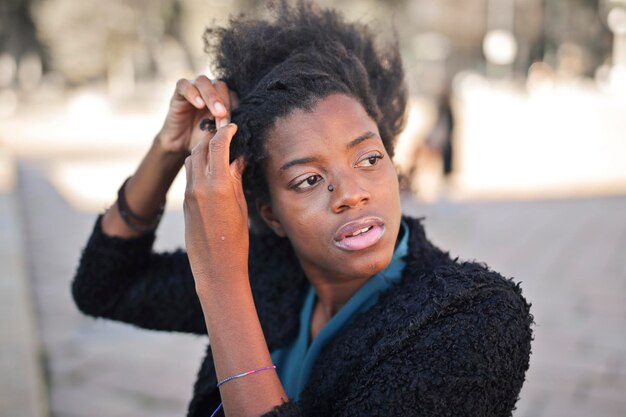jonge zwarte vrouw kamt haar haar