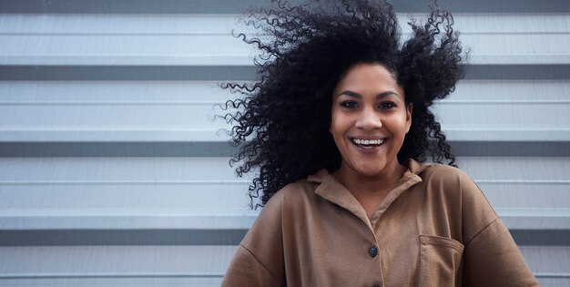 jonge zwarte vrouw met afro haar lachen en genieten