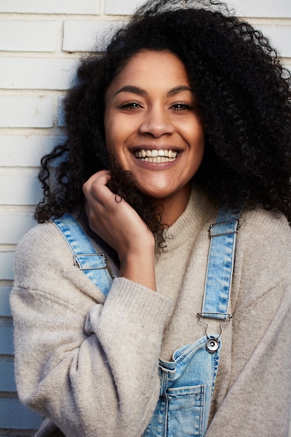 Gratis foto jonge zwarte vrouw met afro haar lachen en genieten