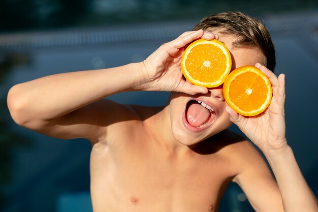 Jongen bij het zwembad met citrus