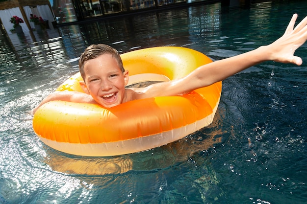 Jongen bij het zwembad met poolvlotter