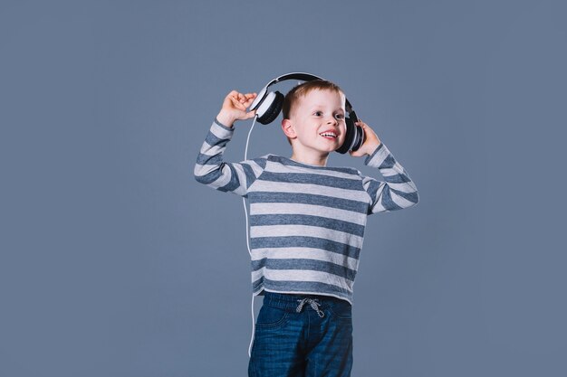 Jongen die aan muziek in hoofdtelefoons luistert