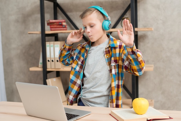 Jongen die aan muziek op laptop luistert