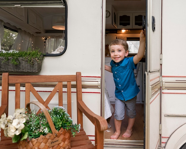 Jongen die de deur van zijn caravan vasthoudt