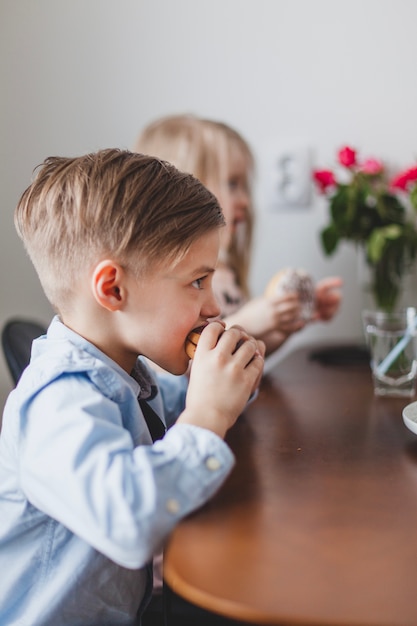 Jongen die een smakelijke donut bijt