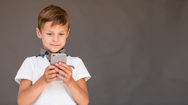 Jongen die een spel op de telefoon met exemplaarruimte speelt