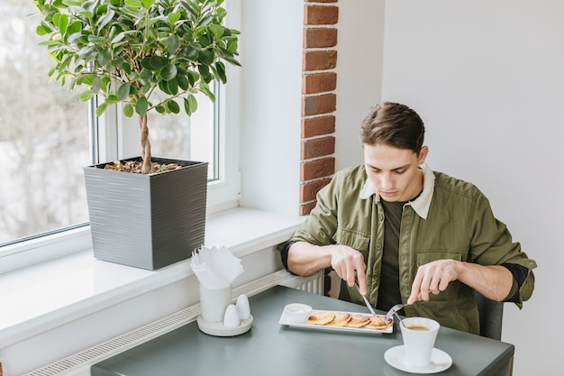 Gratis foto jongen die in een restaurant eet