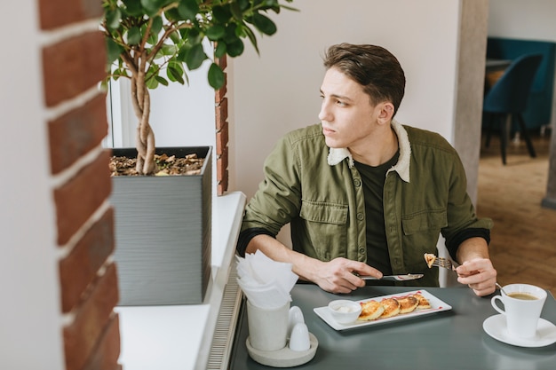 Gratis foto jongen die in een restaurant eet