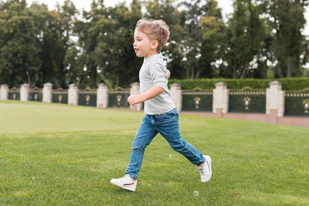 Jongen die op gras loopt