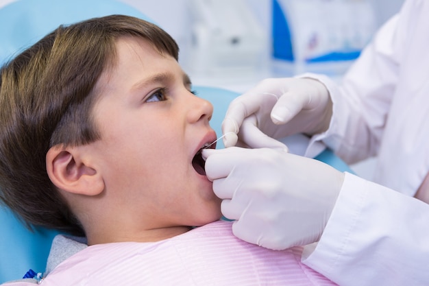 Jongen die tandheelkundige behandeling door tandarts ontvangt
