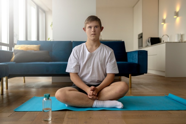 Gratis foto jongen doet yoga thuis vooraanzicht